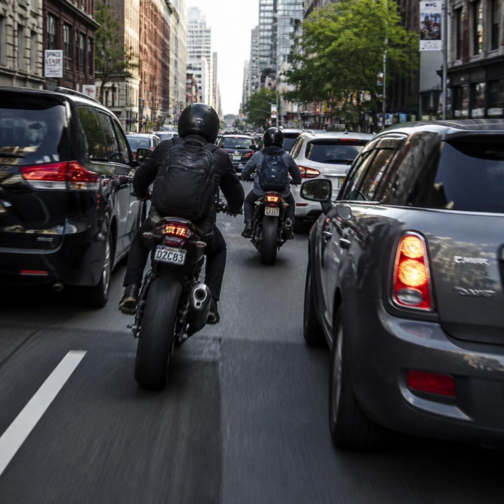 渋滞路で後続のライダーからすり抜けを促されている場面のイメージ